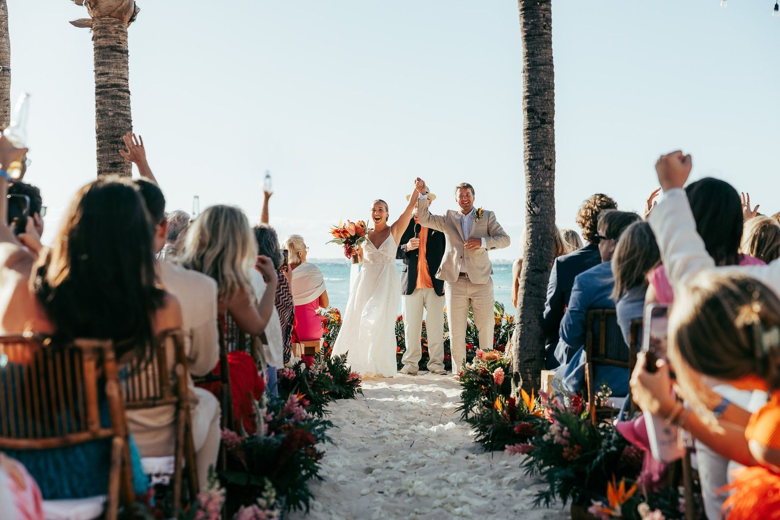 La pareja celebra al final de la ceremonia en la playa